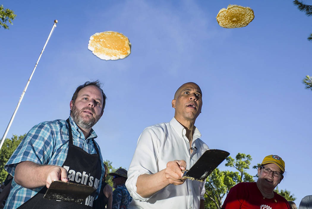 Nevada Treasurer Zach Conine, left, flips pancakes with Democratic presidential candidate Sen. ...
