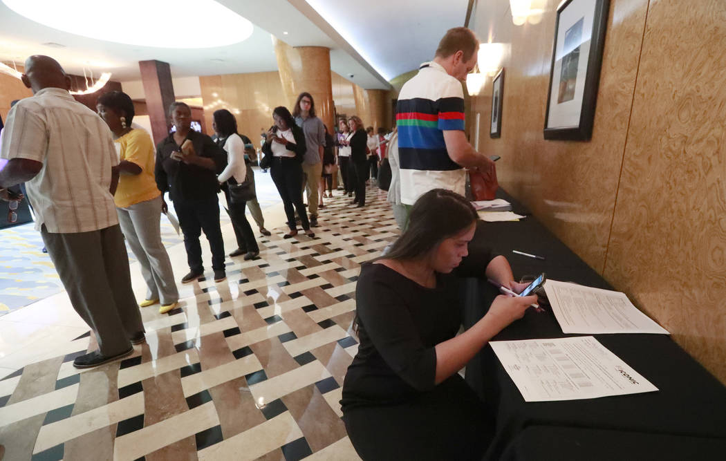 In this Tuesday, June 4, 2019 photo, Emily Esparza, lower right, fills out a questionnaire as o ...
