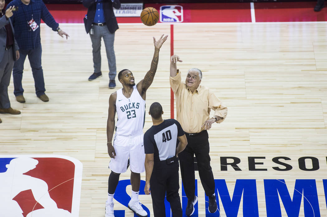 Gov. Steve Sisolak, right, participates in a tip off with Milwaukee Bucks' Sterling Brown (23) ...