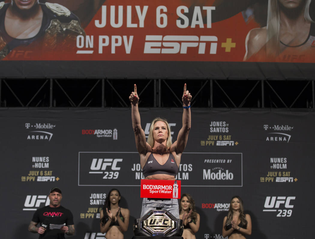 UFC bantamweight Holly Holm points to the crowd while on the scale during weigh ins for UFC 239 ...