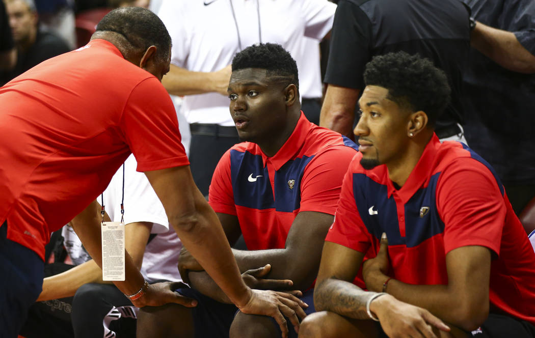 New Orleans Pelicans' Zion Williamson, center, talks with a member of staff on his team before ...
