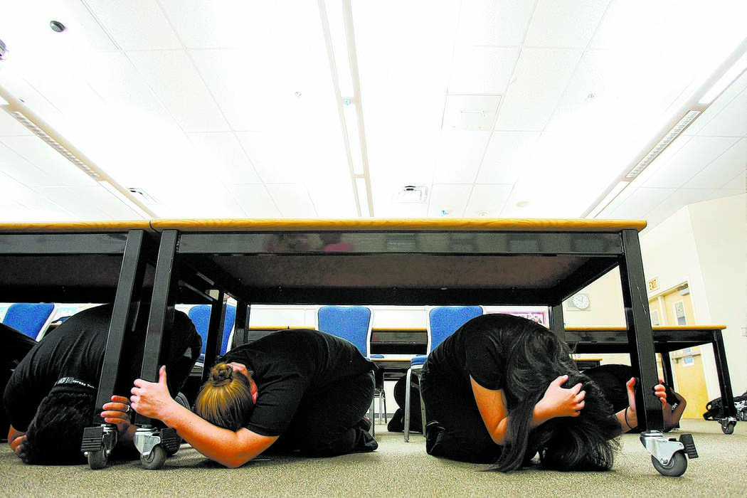 Students Nikki Lee, center left, and Abegayle Boro, right, drop for cover during practice for T ...