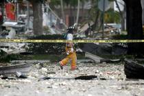 A firefighter walks through the remains of a building after an explosion on Saturday, July 6, 2 ...