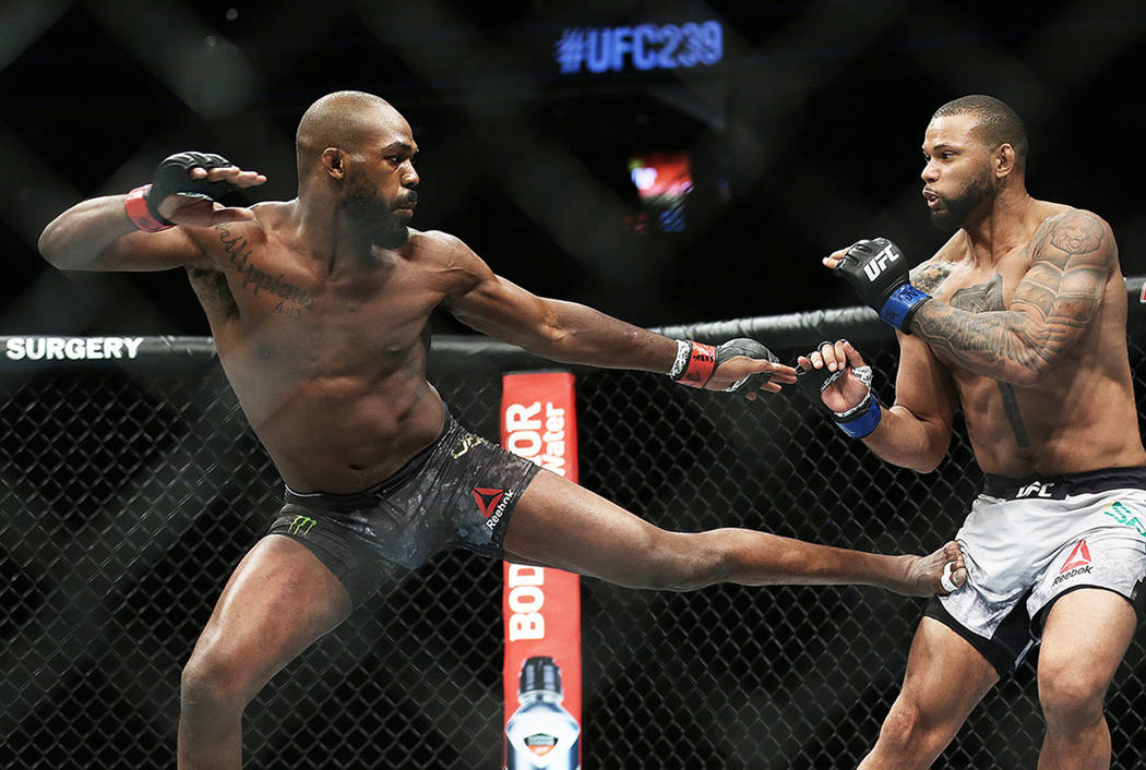 Jon Jones, left, lands a kick against Thiago Santos in the fourth round during their light heav ...