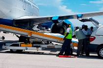 In this handout photo released by the Bahamas ZNS Network, employees oversee the arrival of the ...