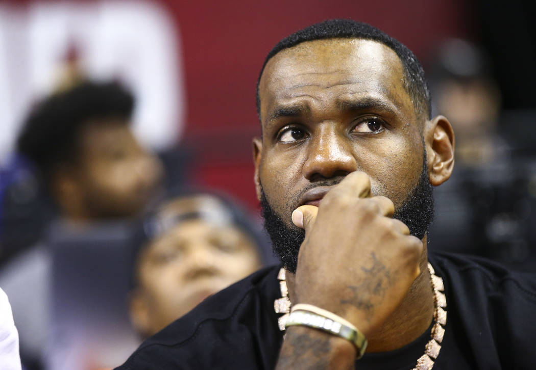 Los Angeles Lakers' LeBron James sits courtside before the start of a game between the Los Ange ...