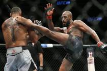 Jon Jones, right, lands a high kick against Thiago Santos in the first round during their light ...