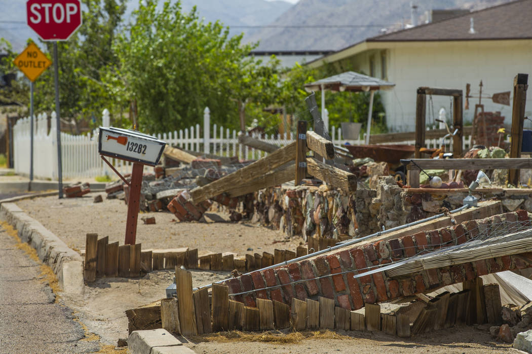 A brick and wooden wall in front of a home is one of many structures damaged from recent earthq ...