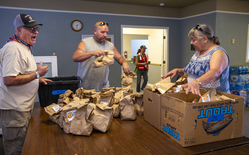 Charlie Eisenhour, left, works with Lynne Darlin, right, and others to coordinate the incoming ...