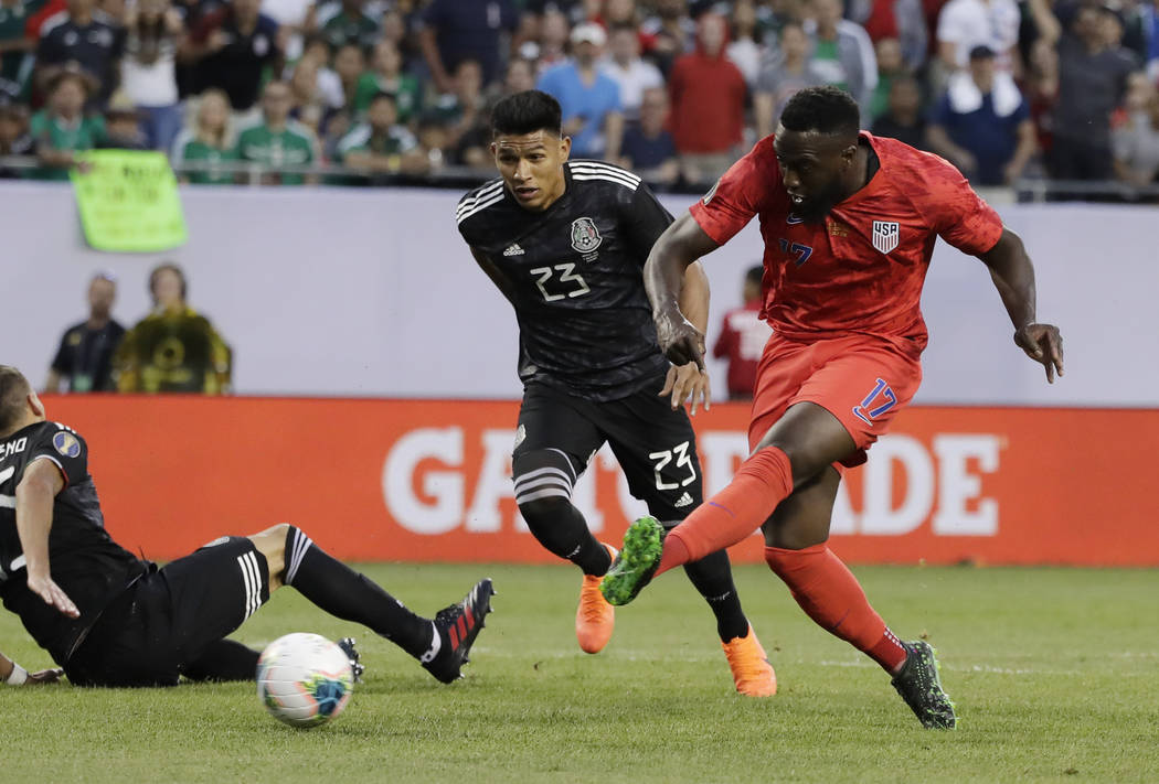 United States forward Jozy Altidore, right, shoots against Mexico midfielder Jesus Gallardo dur ...