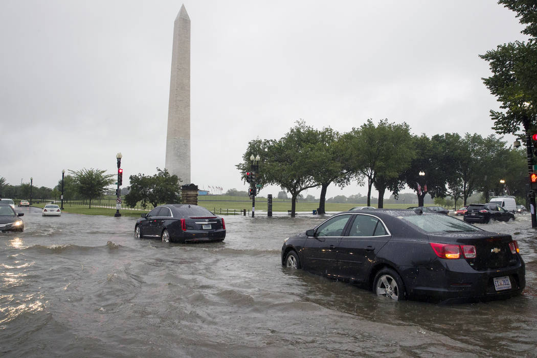 Heavy rainfall flooded the intersection of 15th Street and Constitution Ave., NW stalling cars ...