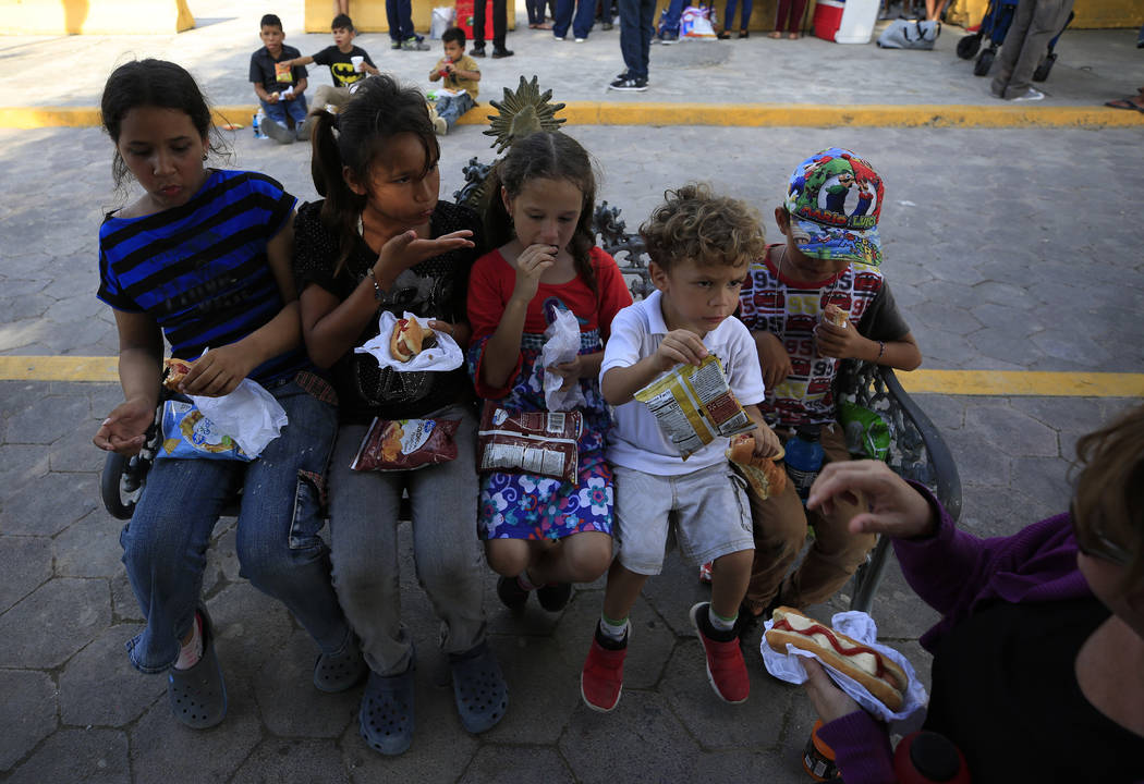 Migrant children eat a meal provided by United in Christ Ministry of Los Fresnos, Texas, a grou ...
