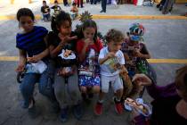 Migrant children eat a meal provided by United in Christ Ministry of Los Fresnos, Texas, a grou ...
