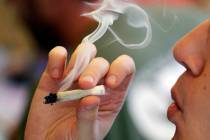 FILE - In this April 20, 2016, file photo, a man smokes a marijuana joint at a party celebratin ...