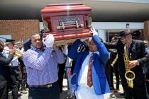Pallbearers carry the coffin of Dave Bartholomew past the Treme brass band as they exit St. Gab ...