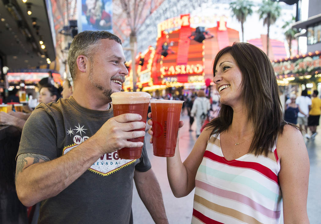 Kevin Thomason, left, and Melissa Bennett celebrate after ordering 32-ounce red beers on Friday ...