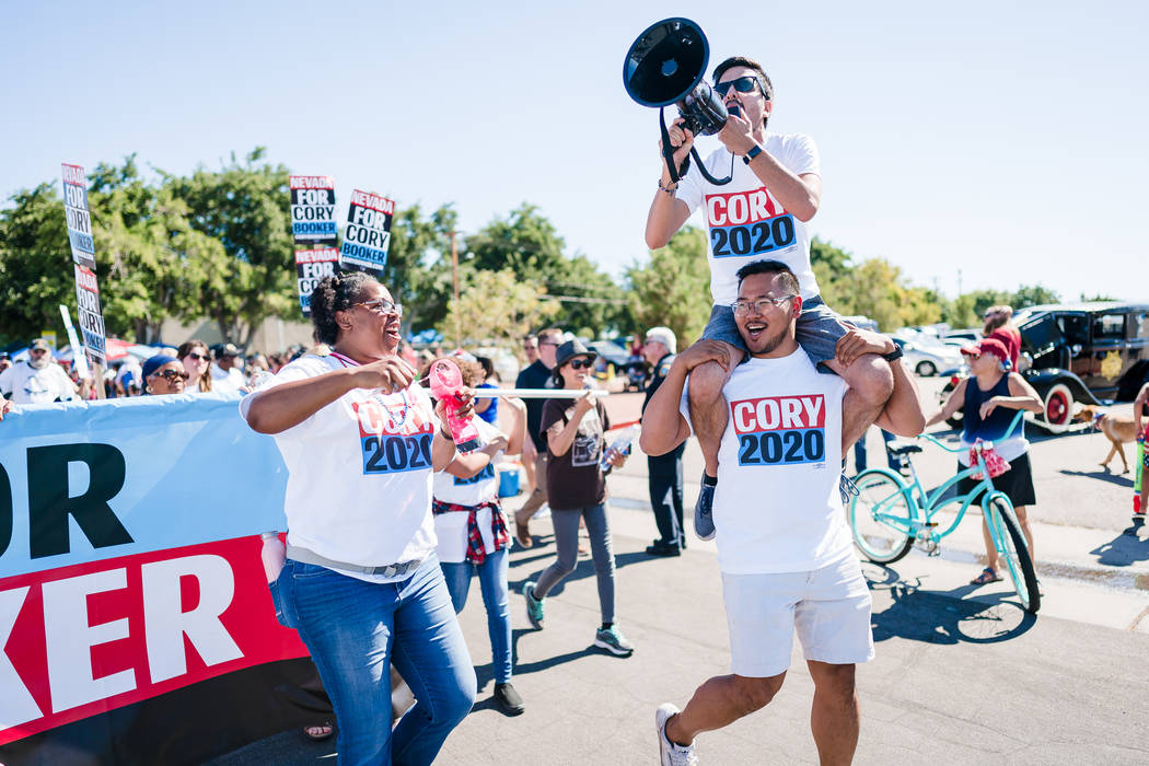 Cory Booker for President organizer ShaRonda Ramos, left, Nevada state director Phil Kim, botto ...