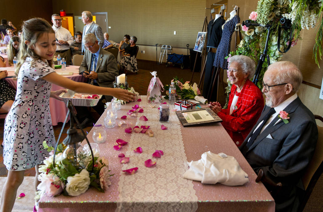 Allison Bailey, 9, left, sprinkles rose petals to the delight of Donna and Gail Andress during ...