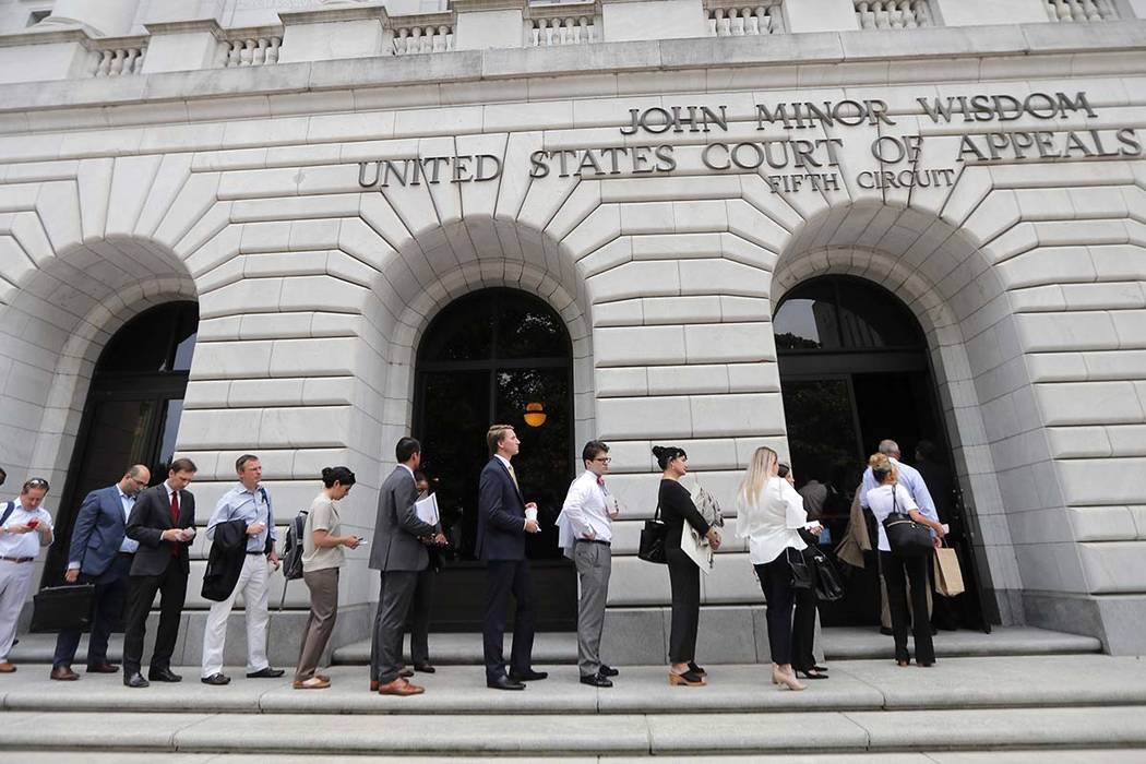 People wait in line to enter the 5th Circuit Court of Appeals to sit in overflow rooms to hear ...