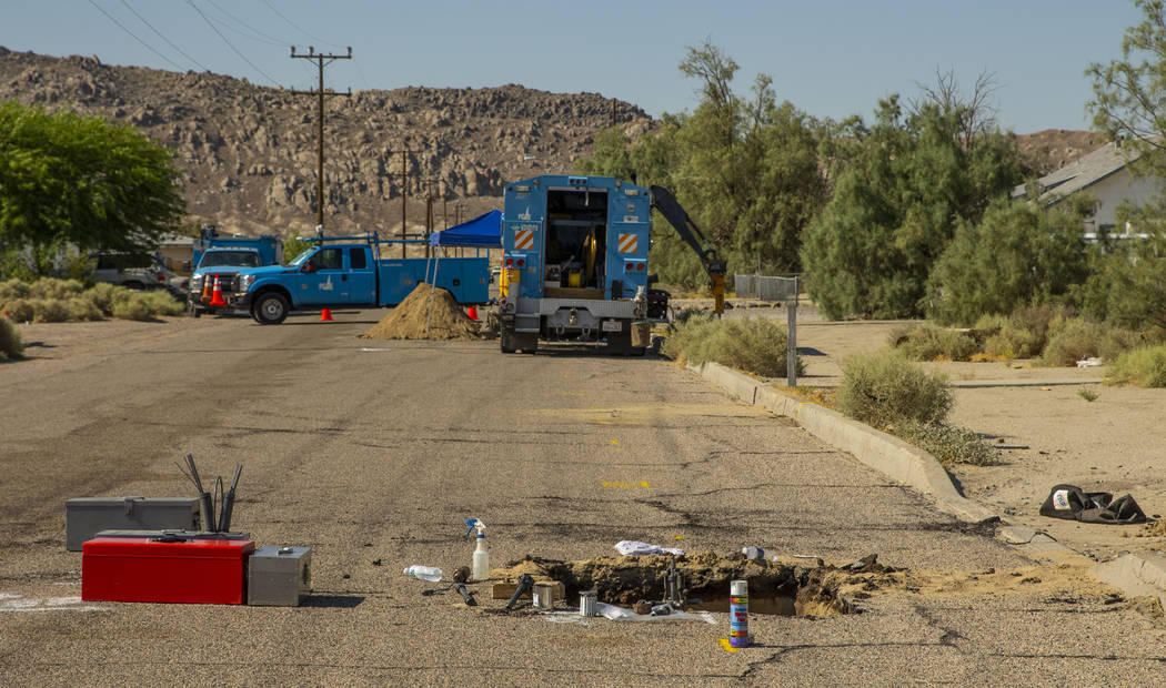An open hole revealing a broken gas line is repaired by a PG&E crew in Trona, CA., due to t ...