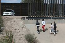 A group of asylum seekers cross the border between El Paso, Texas, and Juarez, Chihuahua, Mexic ...