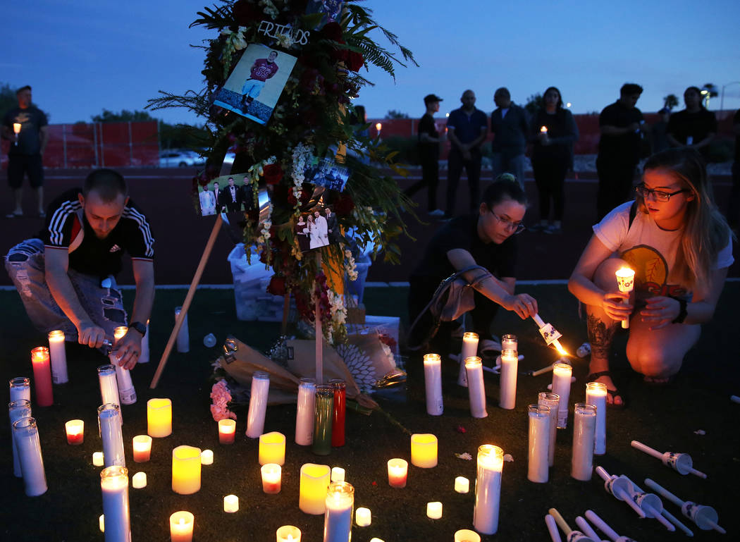 Brian Roberts, left, Carly Blemishes and Deidre Evans light candles during a vigil for Malik No ...