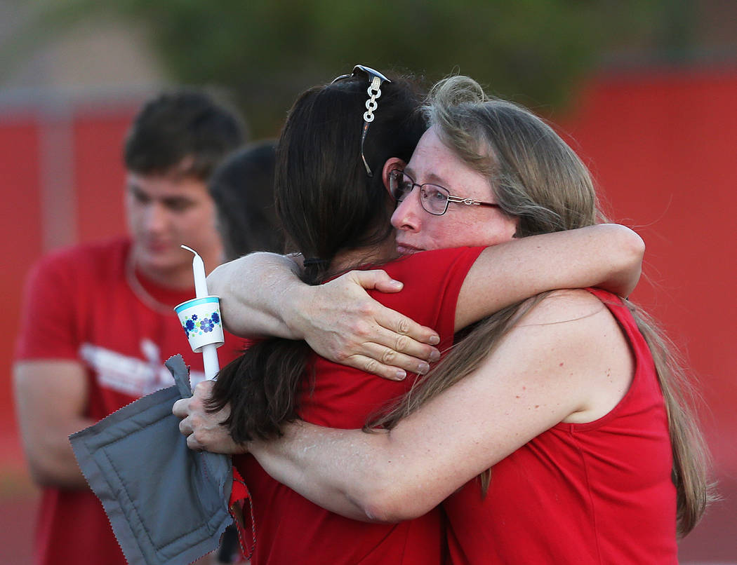 Sarah Newton, right, hugs a friend during a vigil for Malik Noshi, a former Arbor View High Sch ...