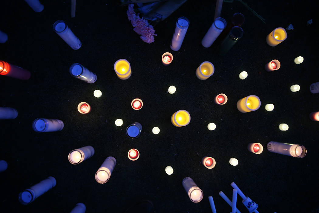 Candles cover the end zone at Arbor View High School football field during a vigil for Malik No ...