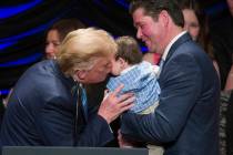 President Donald Trump kisses Hudson Nash, being held by father Andrew Nash, as Trump speaks ab ...