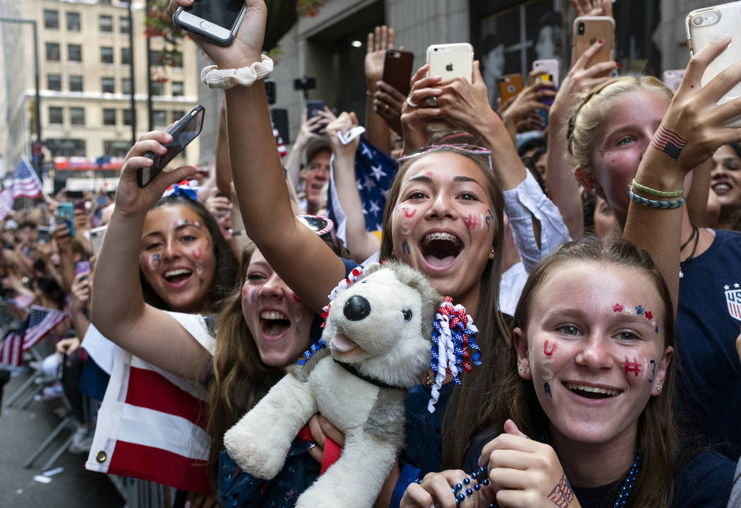 Fans celebrates as members of the the U.S. women's soccer team pass by during a ticker tape par ...