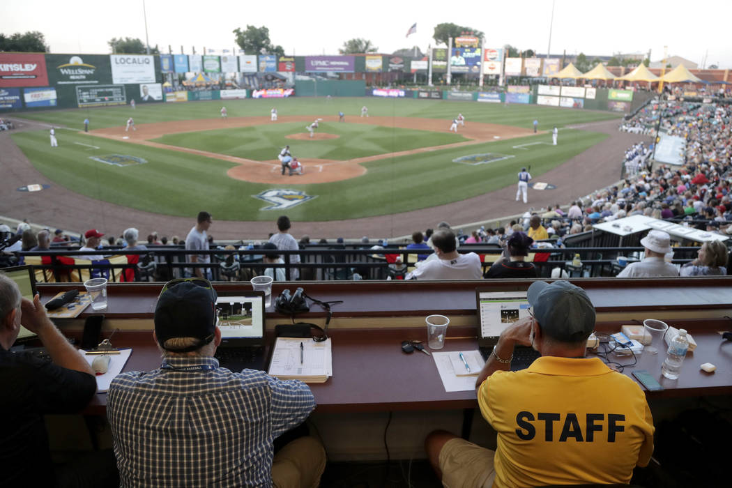 Ron Besaw, right, operates a laptop computer as home plate umpire Brian deBrauwere, gets signal ...