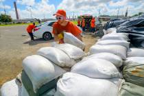 St. Bernard Parish Sheriff's Office inmate workers move free sandbags for residents in Chalmett ...