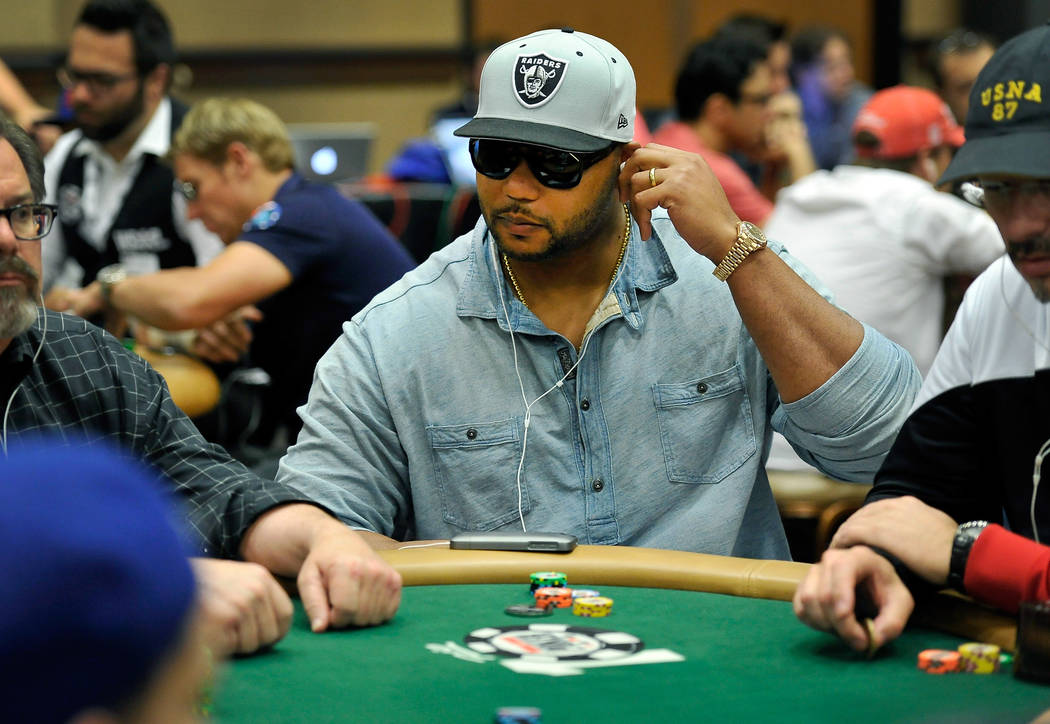 NFL player and poker player Richard Seymour adjusts his ear buds as he plays during Day 1C of t ...