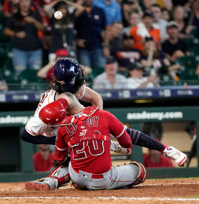 Houston Astros' Jake Marisnick, right, collides Los Angeles Angels catcher Jonathan Lucroy (20) ...