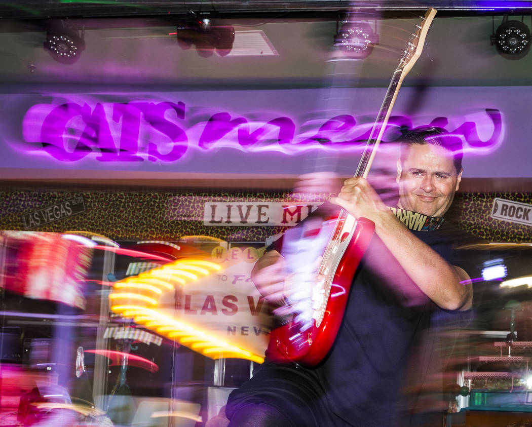 William Chrissikopoulos uses a guitar as a prop while performing at Cat's Meow karaoke club on ...