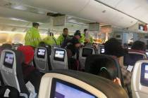 Emergency workers treat a passenger on an Air Canada flight to Australia that was diverted and ...