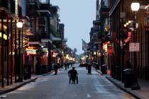A man in a wheelchair makes his way down Bourbon Street in the French Quarter Saturday, July 13 ...