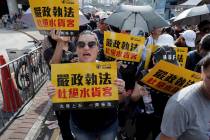 Protesters hold up words that read: "Strict enforcing of law against smugglers of grey goo ...
