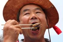 A member of the Korean Dog Meat Association eats dog meat during a rally to support eating the ...