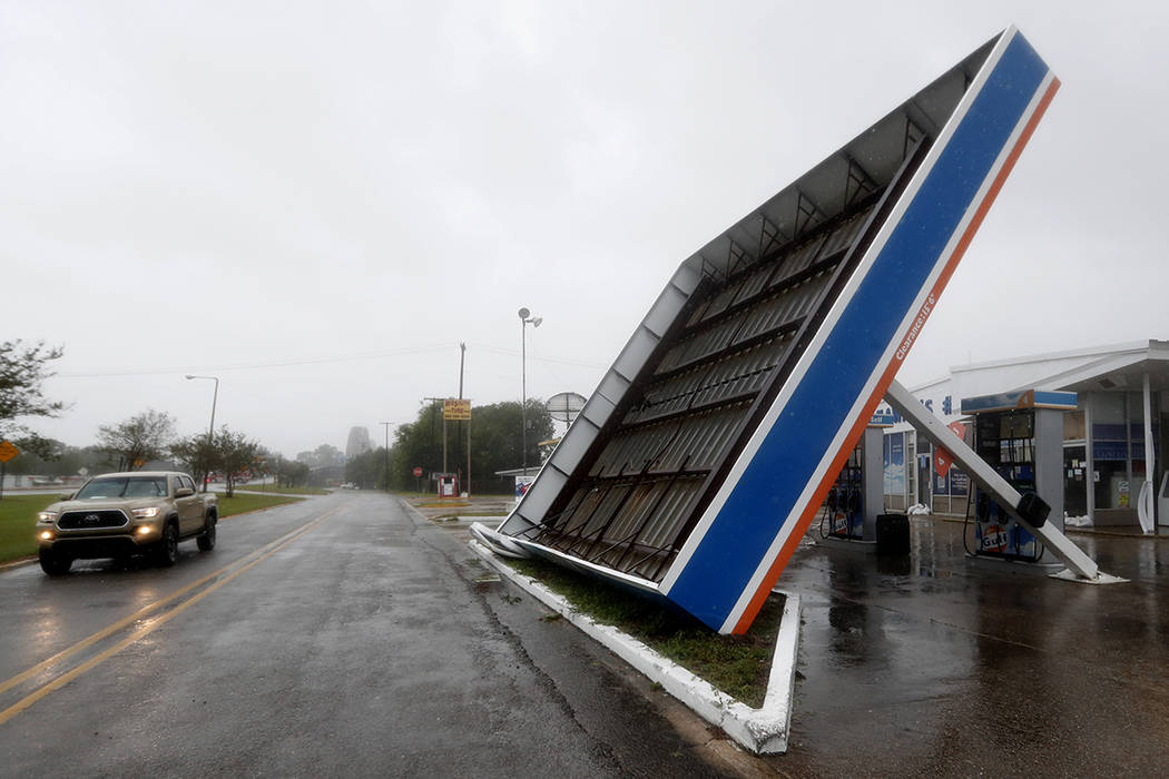 A vehicle passes a toppled gas pump canopy in Berwick, La., following a severe weather assault ...