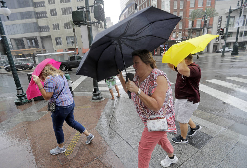 Martha Young, center, Patricia Plishka, left, and her husband Glen, right, battle the wind and ...