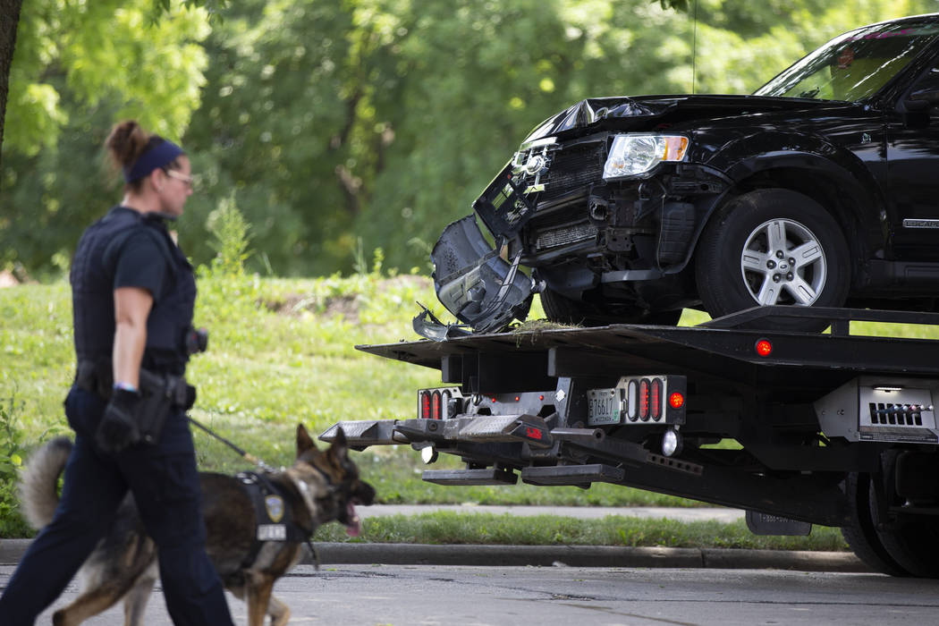 An automobile believed to be driven by a suspect is removed from the scene during an active inv ...