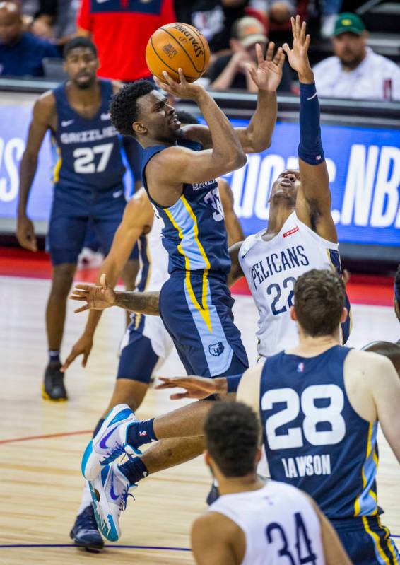 Memphis Grizzlies guard Keenan Evans, left, elevates to the basket over New Orleans Pelicans gu ...