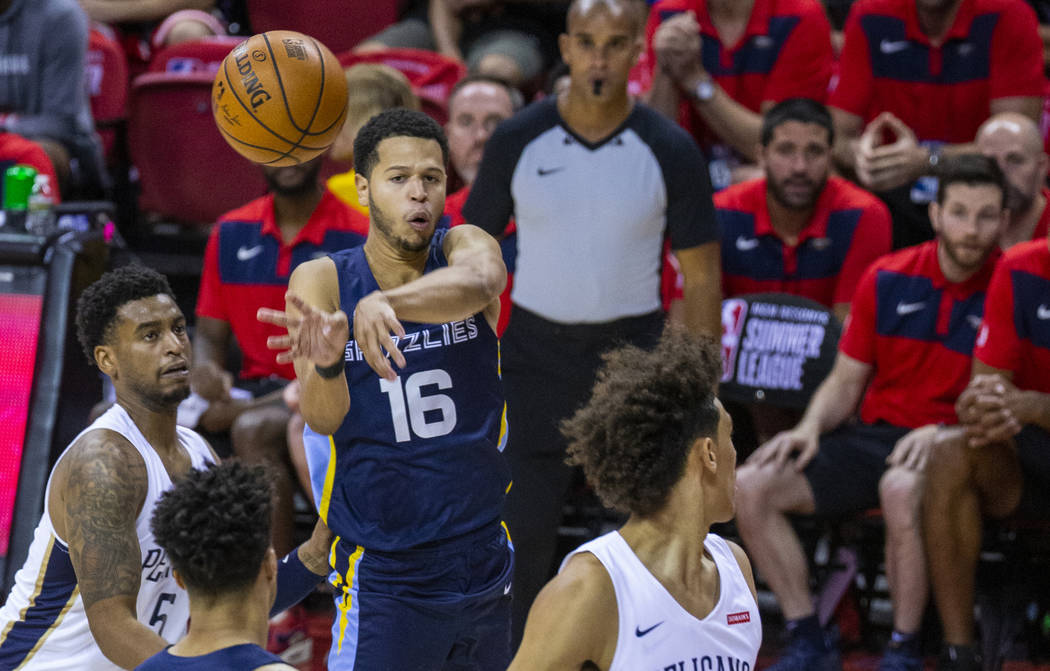 Memphis Grizzlies guard Tyler Harvey gets off a pass over the New Orleans Pelicans defenders du ...