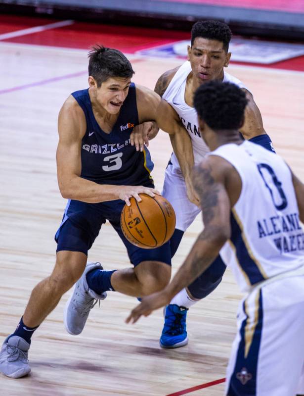 Memphis Grizzlies guard Grayson Allen, left, drives the lane under tight defense by New Orleans ...