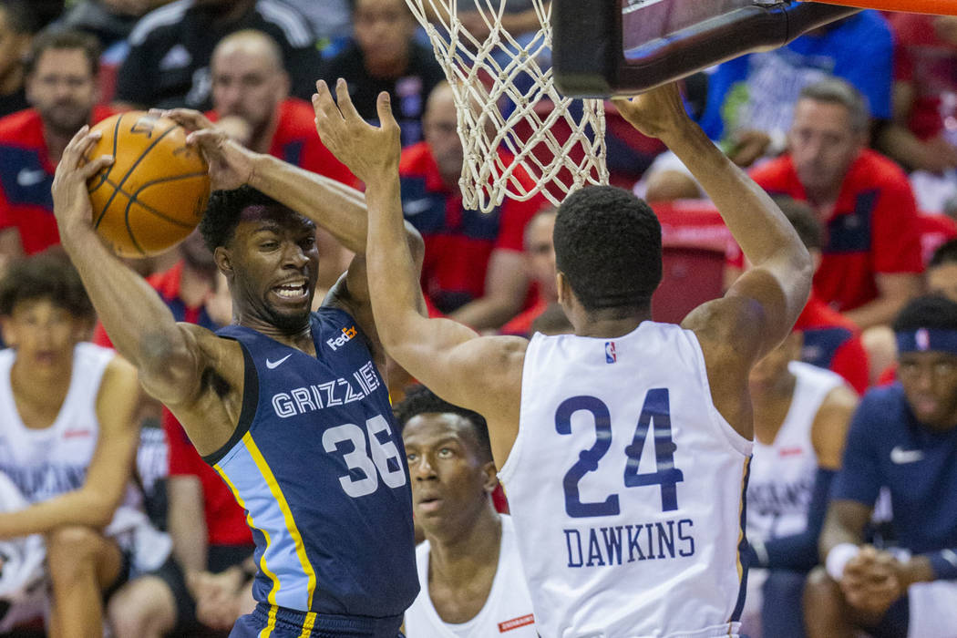 Memphis Grizzlies guard Keenan Evans, left, pills down a rebound over New Orleans Pelicans guar ...