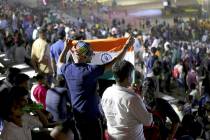 An Indian spectator folds a flag as others leave after the Chandrayaan-2 mission was aborted at ...