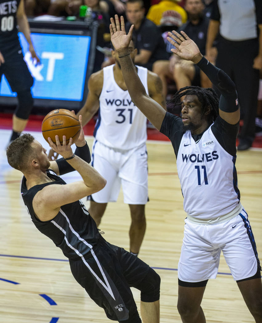 Brooklyn Nets guard Dzanan Musa, left, falls back on a shot attempt as Minnesota Timberwolves c ...