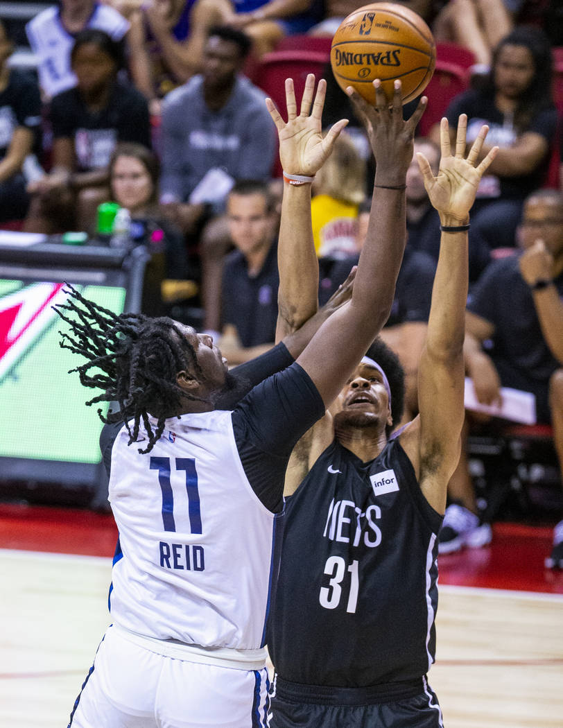 Minnesota Timberwolves center Naz Reid, left, gets off a shot over the Brooklyn Nets center Jar ...