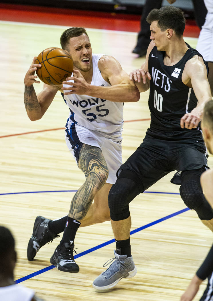 Minnesota Timberwolves forward Mitchell Creek, left, drives the lane under tight defense by Bro ...